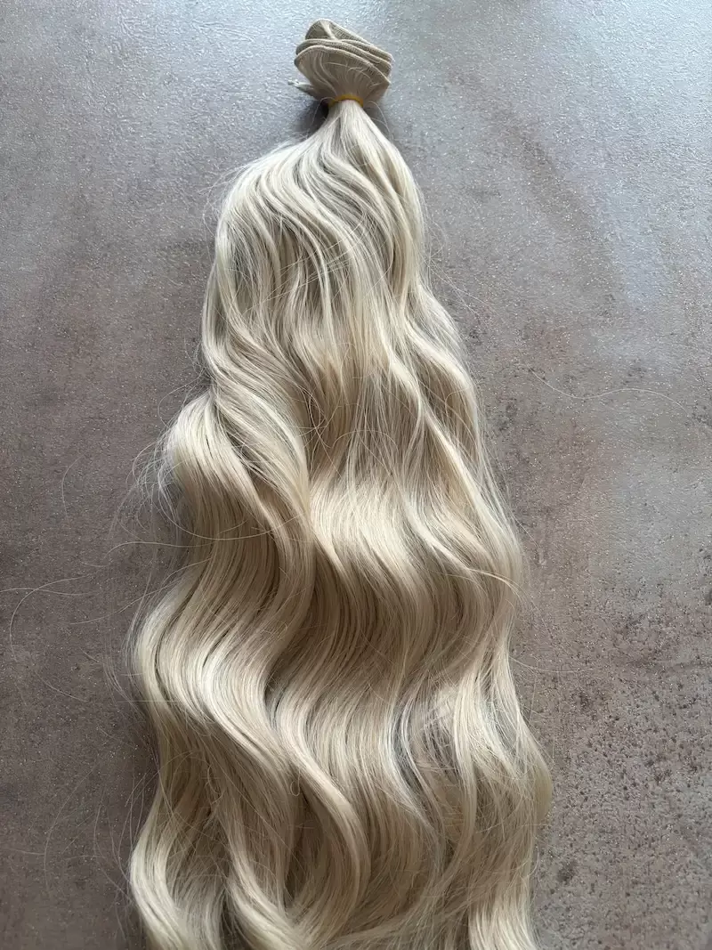 Bézses szőke, enyhén meliros hullámos I. osztályú vasalható szintetikus csatos haj 50cm (52)